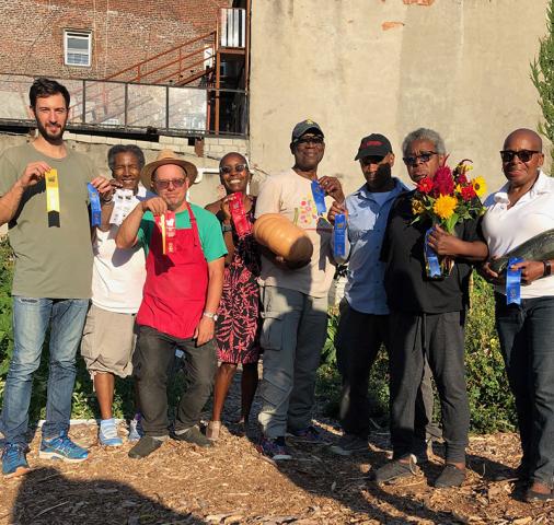 Garden members display the ribbons won at the 2019 GreenThumb Harvest Fair, a citywide event.